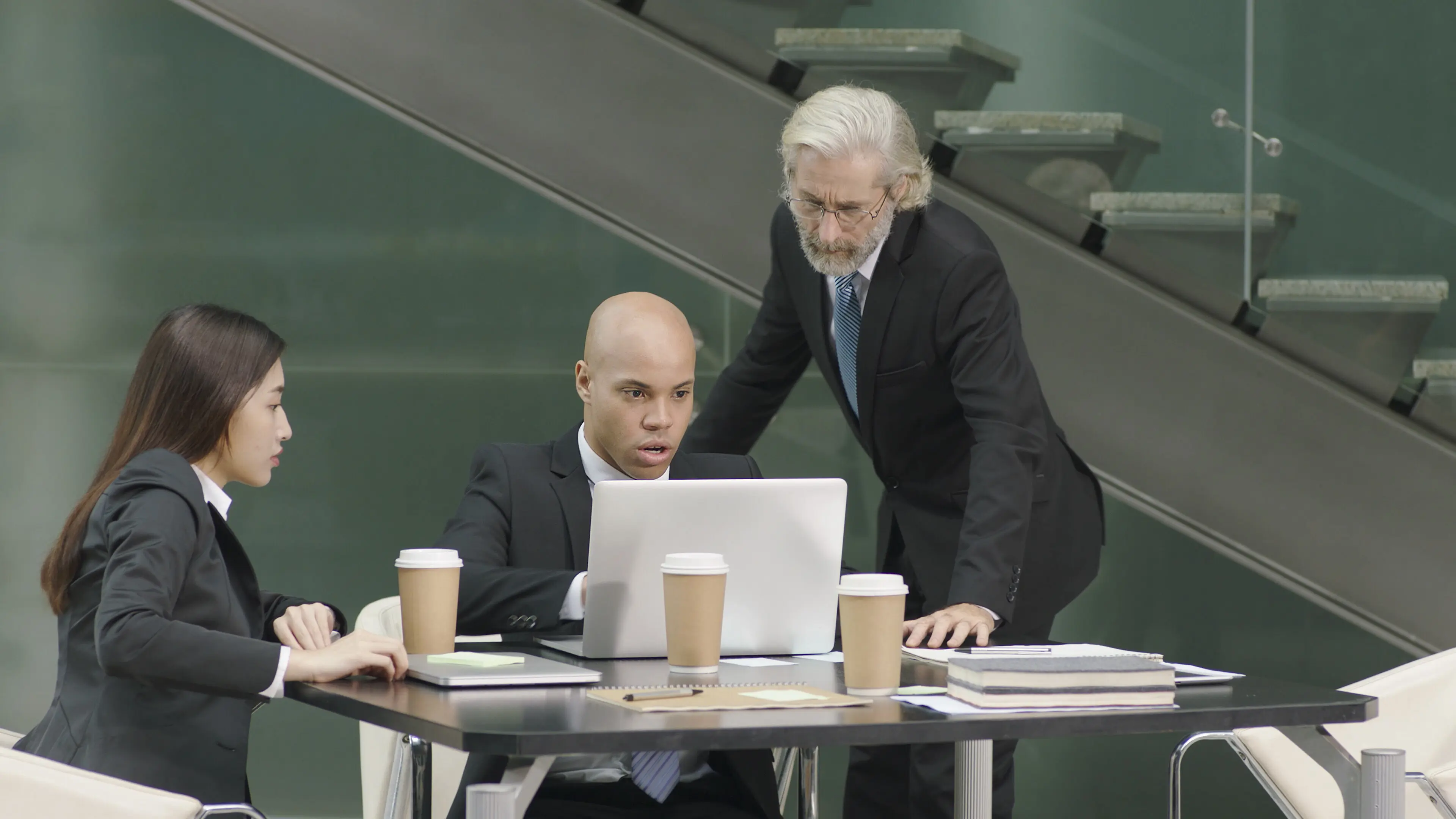 Three corporate executives in an office meeting.